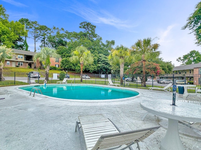 pool featuring a patio area and fence