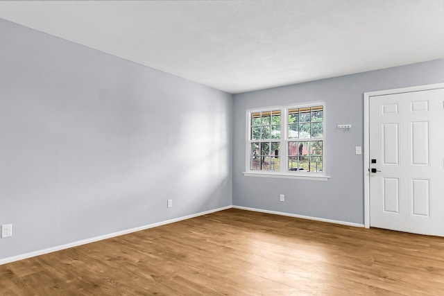 foyer entrance with baseboards and wood finished floors