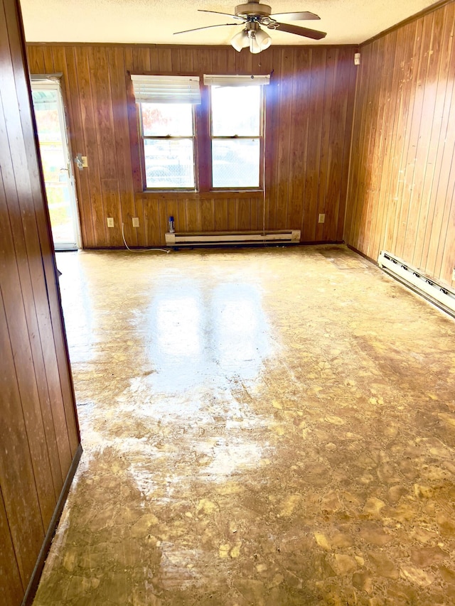 unfurnished room with ceiling fan, wood walls, and a baseboard heating unit