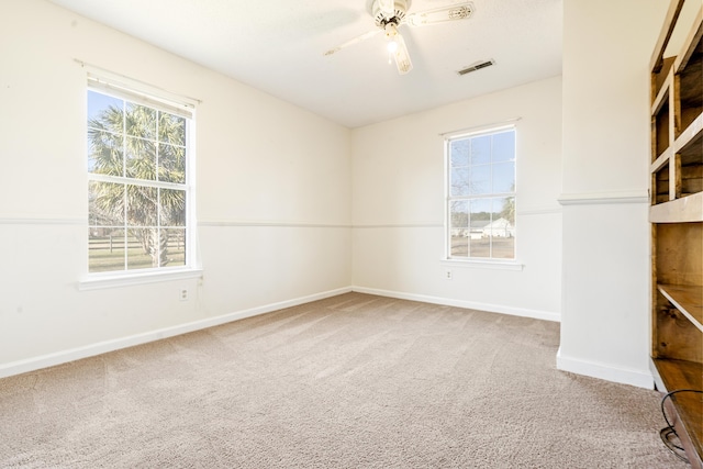 carpeted spare room featuring ceiling fan