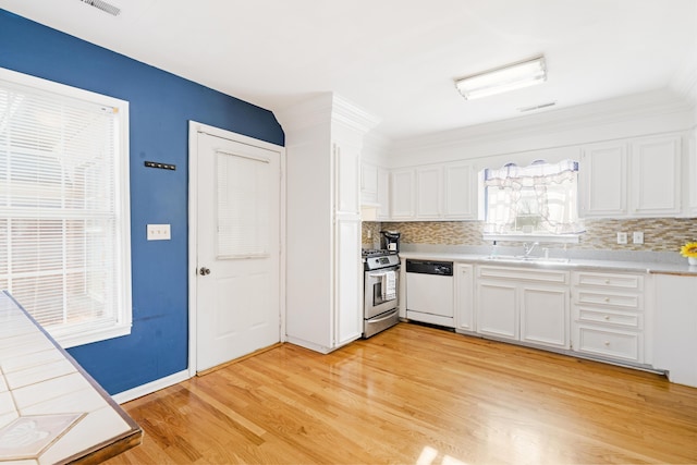 kitchen with dishwasher, sink, stainless steel gas stove, light hardwood / wood-style floors, and white cabinetry