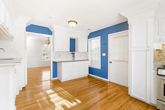 kitchen featuring white cabinetry, electric range, light hardwood / wood-style flooring, a chandelier, and decorative backsplash