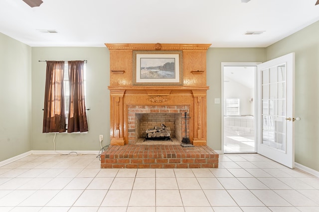 unfurnished living room with a fireplace, light tile patterned floors, and french doors