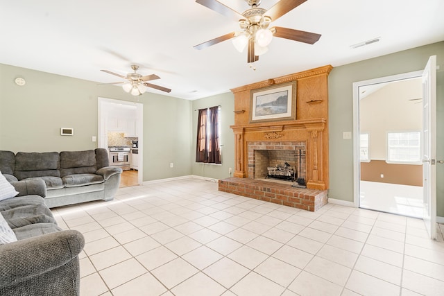 tiled living room with a brick fireplace and ceiling fan