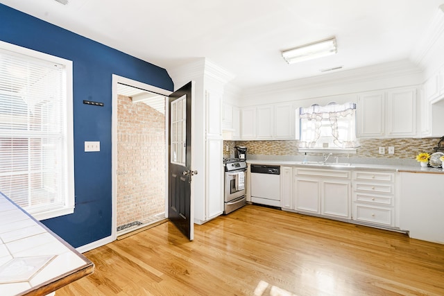 kitchen with white cabinets, sink, dishwasher, light hardwood / wood-style floors, and stainless steel range with gas cooktop