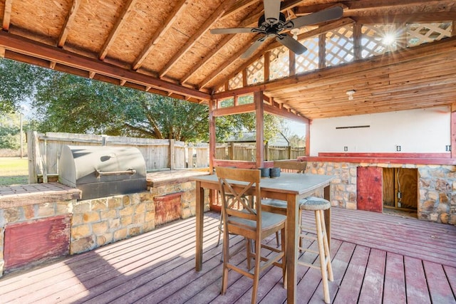 wooden deck with area for grilling, grilling area, and ceiling fan