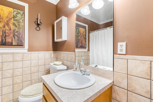 bathroom featuring toilet, vanity, tile walls, and ornamental molding