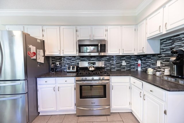 409 Santee Dr, Santee, SC 29142 - kitchen featuring stainless steel appliances, dark countertops, white cabinetry, and crown molding