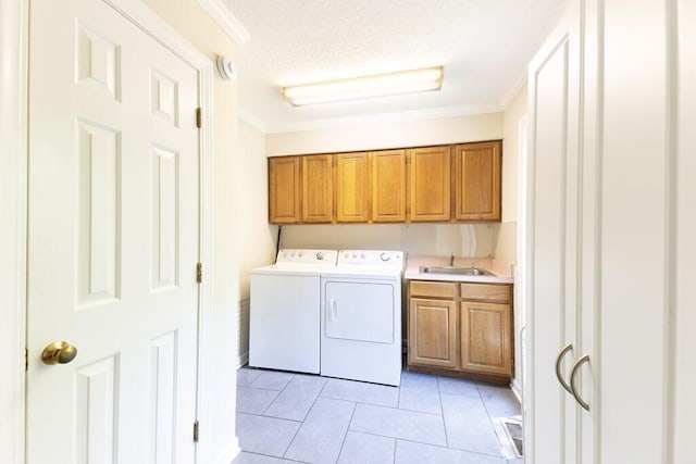 409 Santee Dr, Santee, SC 29142 - laundry area featuring cabinet space, ornamental molding, washing machine and clothes dryer, light tile patterned floors, and a textured ceiling