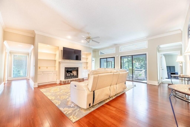 409 Santee Dr, Santee, SC 29142 - living room featuring a ceiling fan, a fireplace, baseboards, wood finished floors, and crown molding