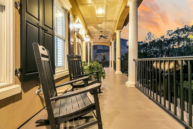 balcony at dusk featuring a porch