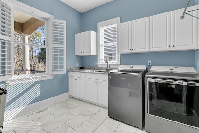 laundry room featuring cabinets, sink, and washing machine and clothes dryer