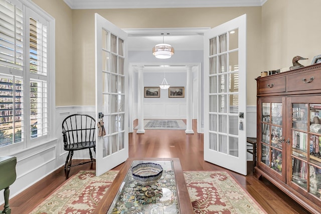 living area with french doors, dark hardwood / wood-style flooring, and ornamental molding