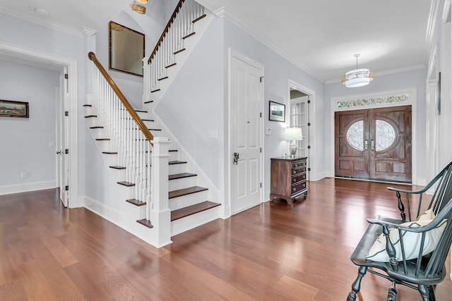 entryway featuring ornamental molding, dark wood-type flooring, and french doors