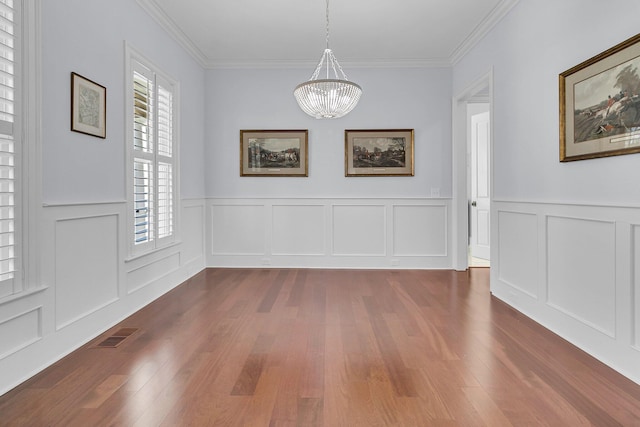 unfurnished dining area with crown molding, dark hardwood / wood-style flooring, and a notable chandelier