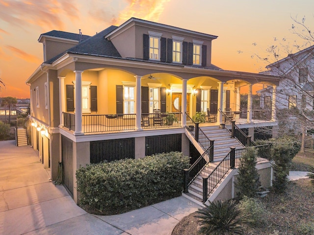 back house at dusk with covered porch and a garage