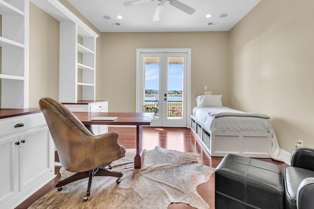 bedroom featuring french doors, access to outside, ceiling fan, dark wood-type flooring, and a water view