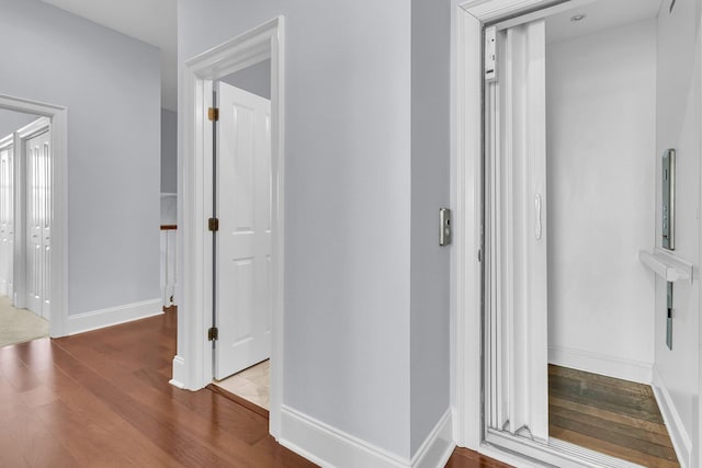 hall featuring hardwood / wood-style flooring and elevator