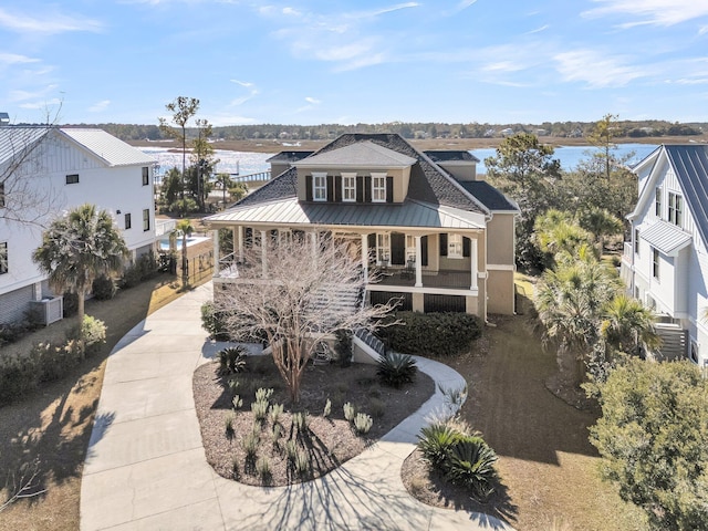 view of front of house with covered porch, central air condition unit, and a water view