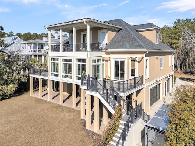 rear view of house featuring a balcony and a garage