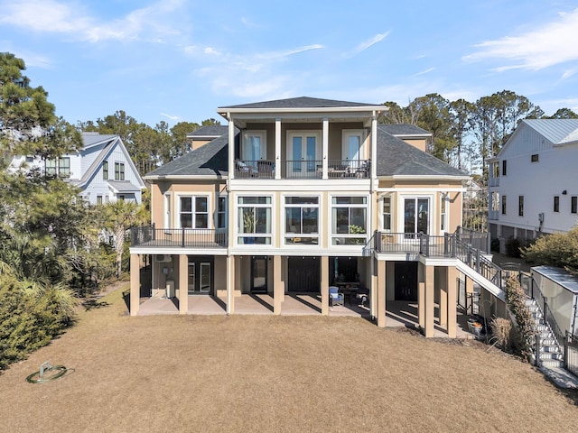 back of house featuring a balcony, a yard, and a patio