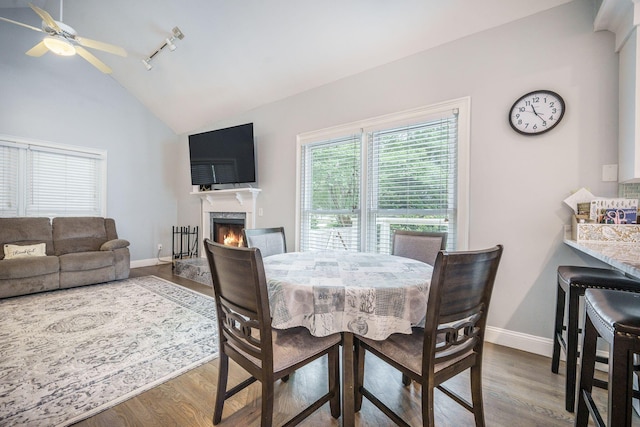 2177 Gulf Dr, Mount Pleasant, SC 29464 - dining space with vaulted ceiling, wood finished floors, a ceiling fan, a high end fireplace, and baseboards