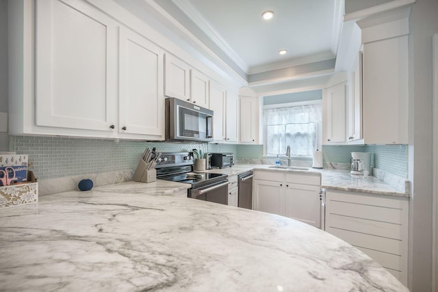 2177 Gulf Dr, Mount Pleasant, SC 29464 - kitchen featuring stainless steel appliances, a sink, crown molding, white cabinetry, and decorative backsplash