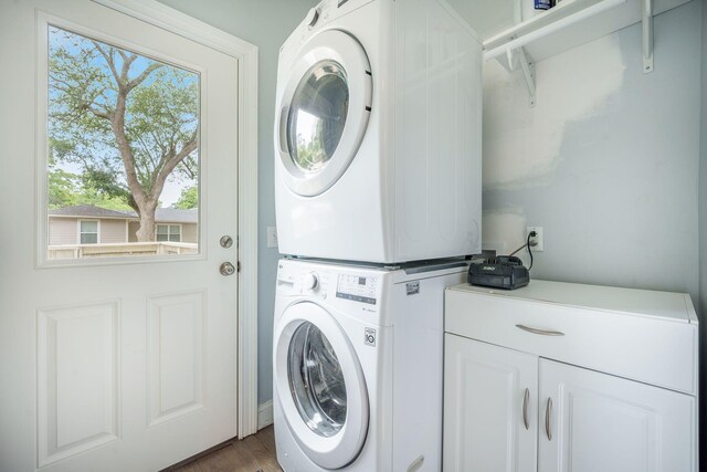 2177 Gulf Dr, Mount Pleasant, SC 29464 - laundry room featuring estacked washer and dryer, cabinet space, and wood finished floors