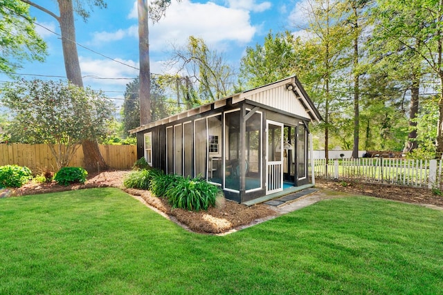 view of outbuilding featuring a sunroom and a lawn