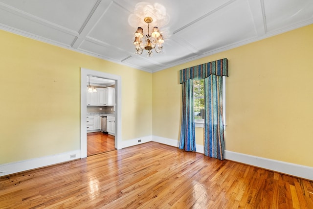 unfurnished room with coffered ceiling, an inviting chandelier, light wood-type flooring, and crown molding