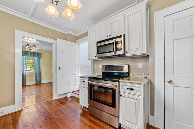 kitchen with stainless steel appliances, wood-type flooring, white cabinets, and a chandelier