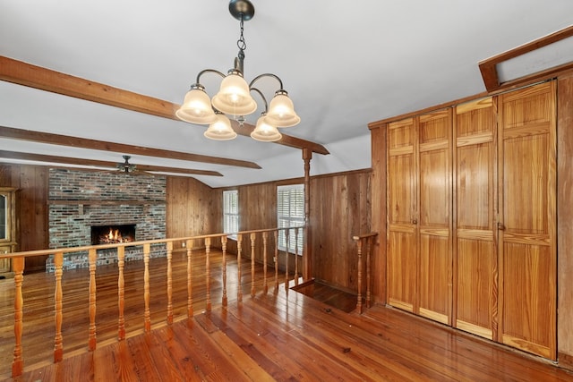 unfurnished living room with wood walls, a fireplace, and hardwood / wood-style flooring