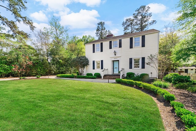 colonial inspired home with a front lawn