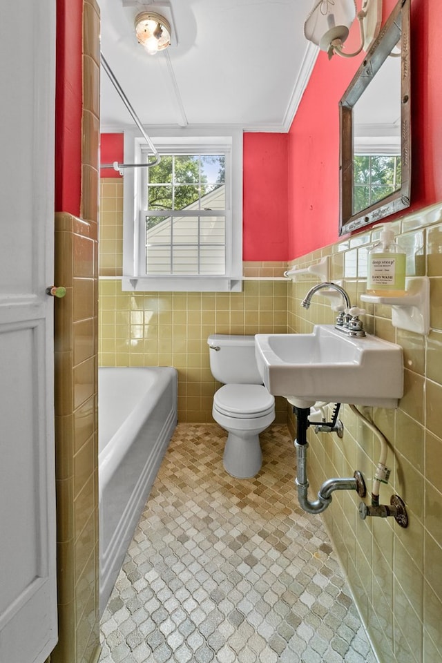 bathroom featuring tile walls, a washtub, and toilet