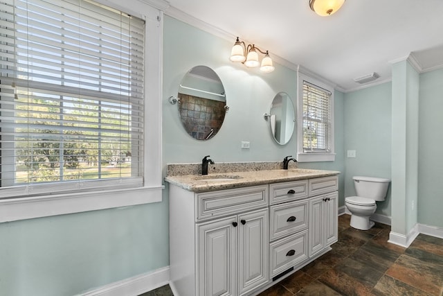 bathroom featuring a healthy amount of sunlight, vanity, toilet, and crown molding