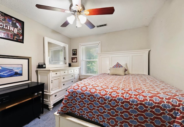 carpeted bedroom featuring a textured ceiling and ceiling fan