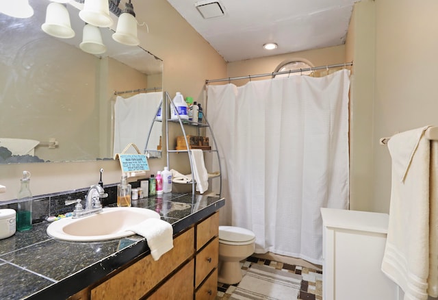 bathroom featuring vanity, toilet, and curtained shower