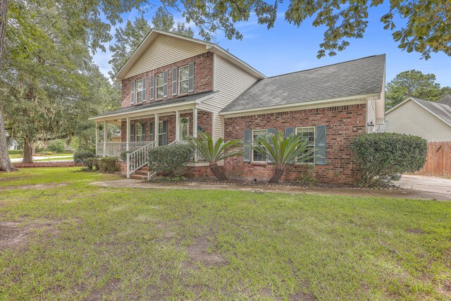 view of front property featuring covered porch and a front yard