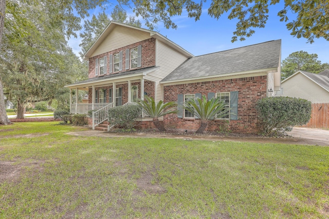 view of front property featuring covered porch and a front yard