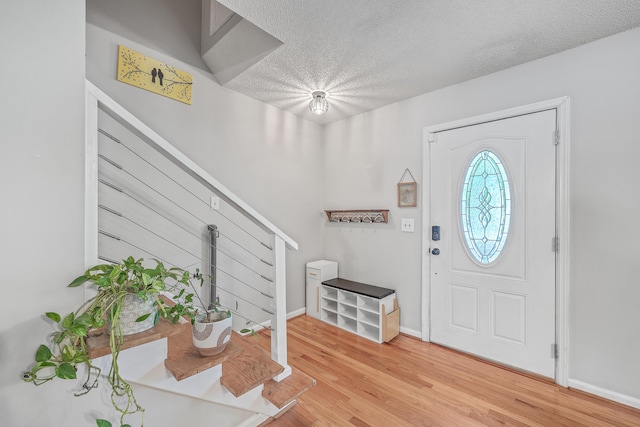 foyer entrance with wood-type flooring and a textured ceiling