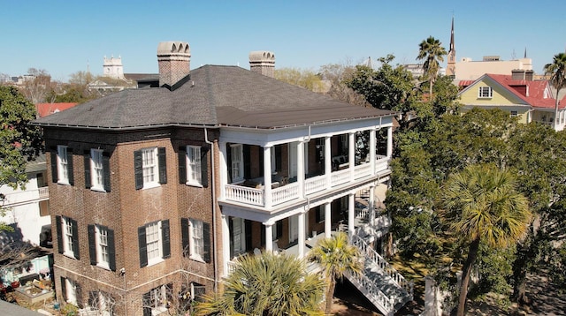 back of property featuring brick siding and a chimney