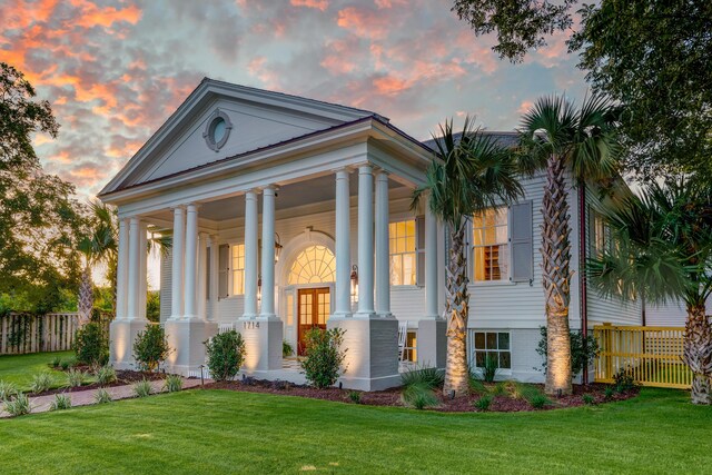 neoclassical / greek revival house featuring a lawn and covered porch