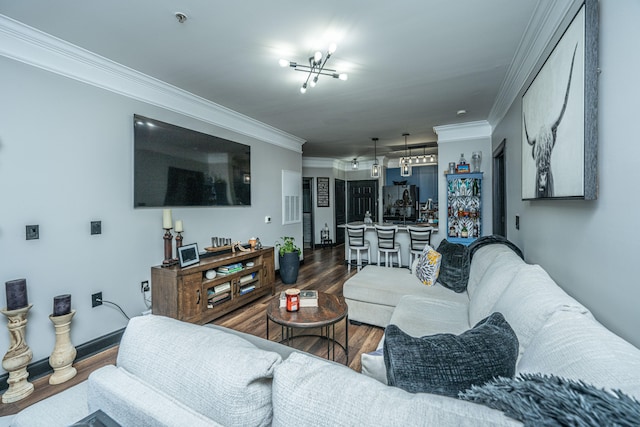 living room with crown molding, dark hardwood / wood-style floors, and an inviting chandelier