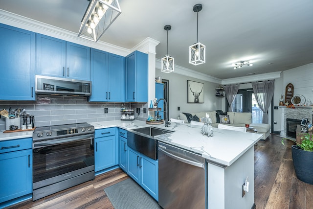 kitchen with kitchen peninsula, appliances with stainless steel finishes, decorative light fixtures, and blue cabinets