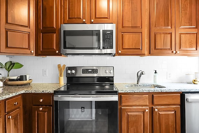4810 Parkside Dr, North Charleston, SC 29405 - kitchen featuring stainless steel appliances, a sink, tasteful backsplash, and light stone countertops