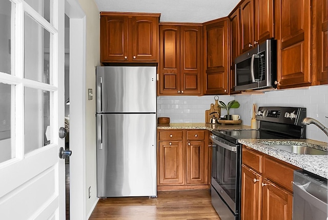 4810 Parkside Dr, North Charleston, SC 29405 - kitchen with appliances with stainless steel finishes, a sink, light stone countertops, and wood finished floors
