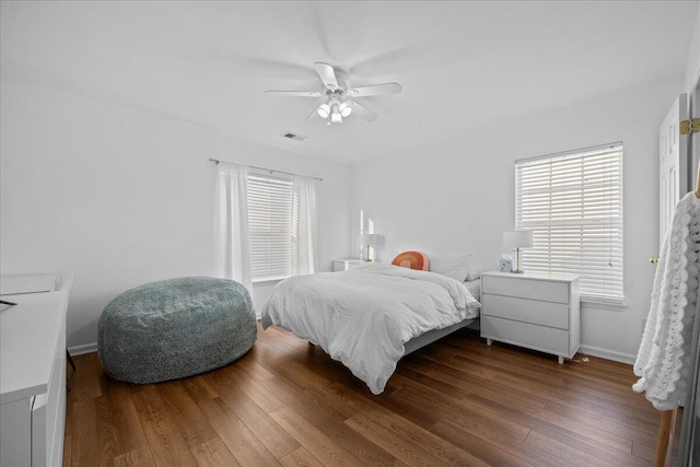 bedroom featuring visible vents, wood-type flooring, a ceiling fan, and baseboards