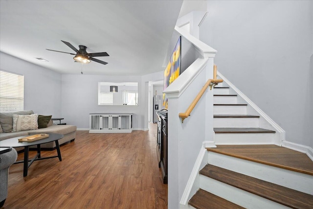 living room with visible vents, stairway, ceiling fan, wood finished floors, and baseboards