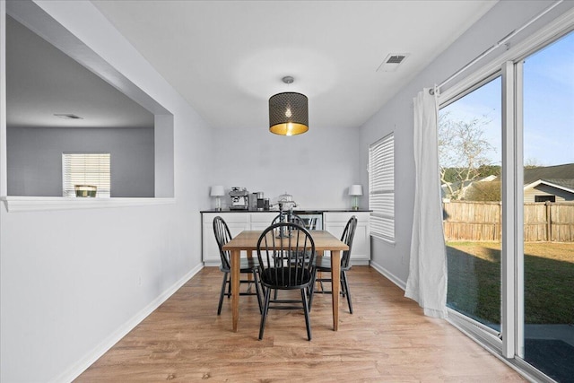 dining area featuring light wood-style floors, visible vents, and baseboards