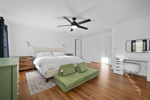 bedroom featuring ceiling fan, visible vents, and wood finished floors